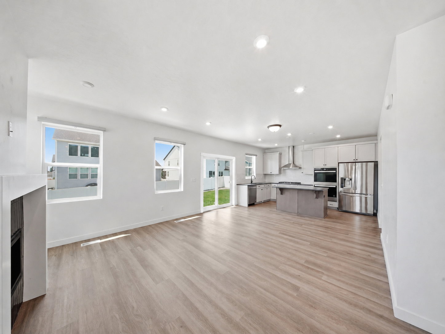 Open-concept living space featuring wood-finish flooring, recessed lighting, and a modern kitchen