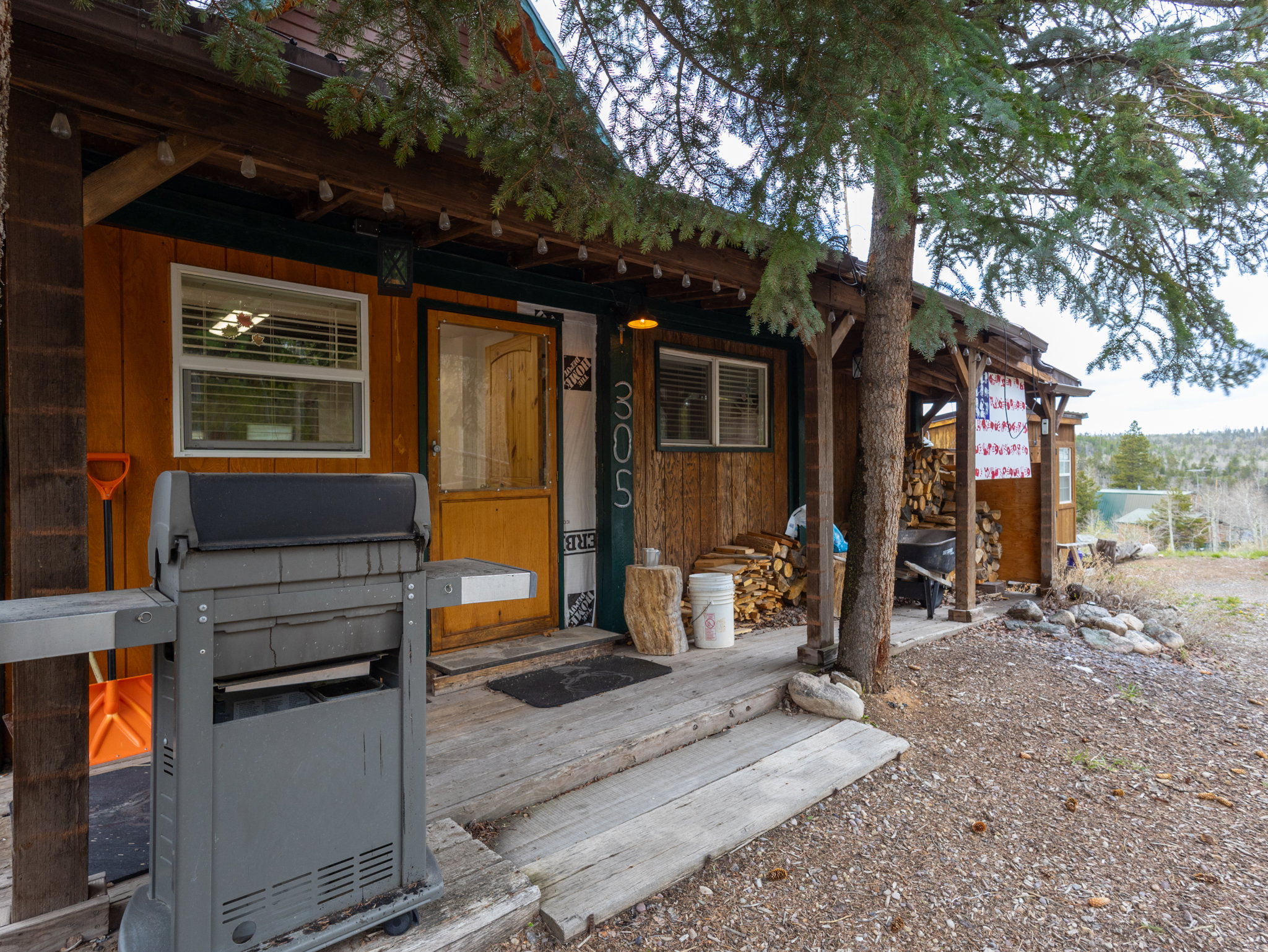 Rustic wood-sided exterior featuring a covered porch, exposed wood beams, and a natural wood entry door