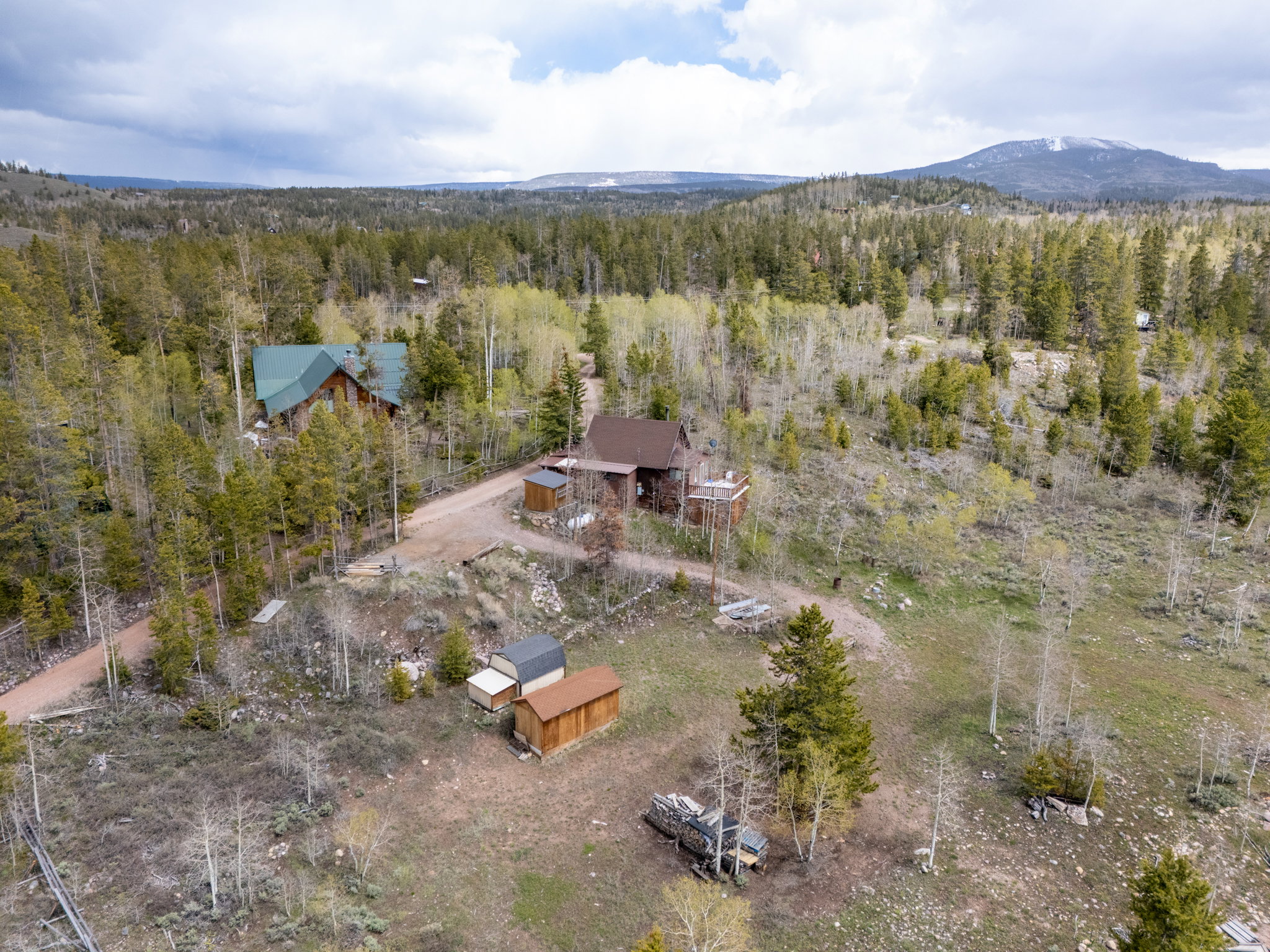 Wooded acreage featuring multiple structures