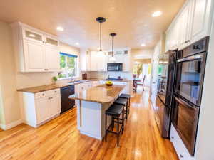 Updated Kitchen Featuring Stacked White Cabinets, Island Bar, Pantry, Double Ovens, & Refrigerator Included