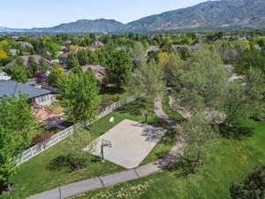 Expansive Outdoor Recreation Area featuring a Paved Sports Court, Mature Trees, and also a Playground & Volleyball area (not shown in photo)