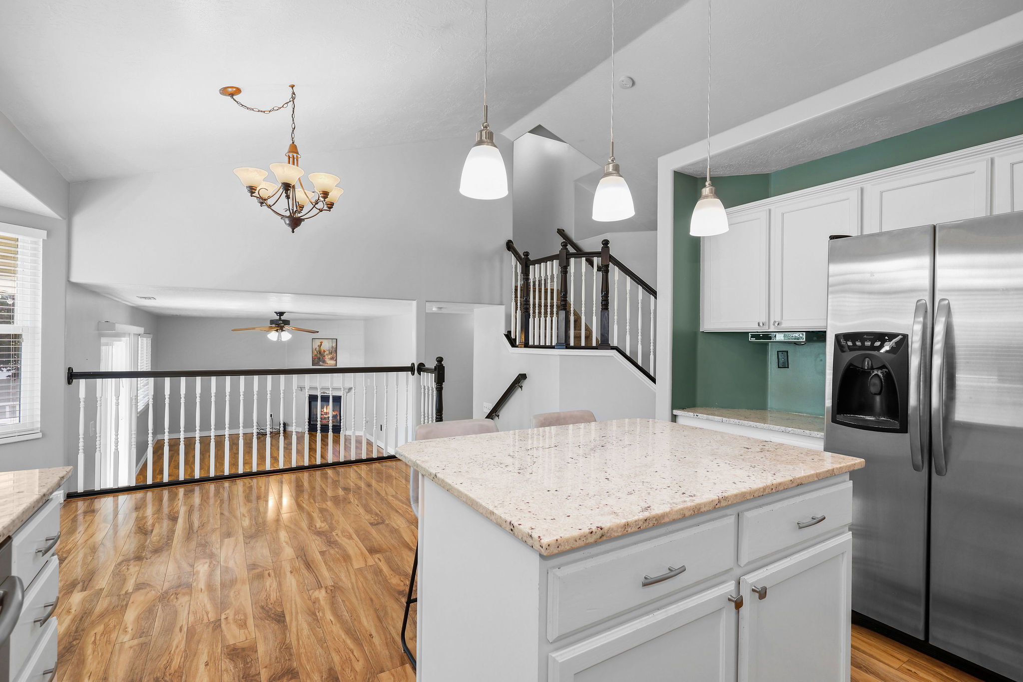 Kitchen island with a light-toned granite countertop and white cabinetry