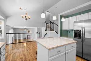 Kitchen island with a light-toned granite countertop and white cabinetry