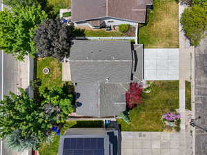Aerial overview showcasing a property with a gray shingle roof, a concrete driveway, and established landscaping