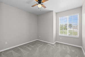 Neutral wall paint, gray carpeting, white trim, a ceiling fan with integrated lighting, and a window with blinds