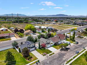 Suburban landscape featuring a residential street, mature landscaping, and a distant mountain range