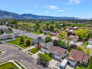 Expansive residential area with mountain backdrop featuring various housing styles and green spaces