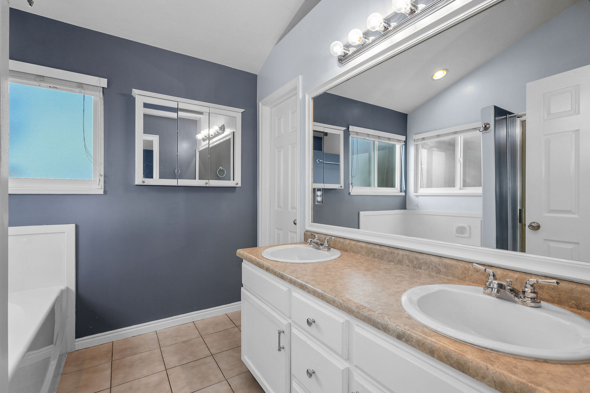 Double vanity with white cabinetry and a light-colored countertop