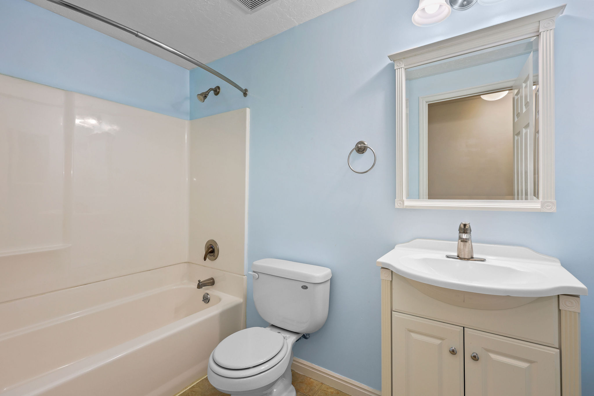 Full bathroom featuring a white tub/shower combination with chrome fixtures, a white toilet, and a vanity with a white countertop and base cabinet