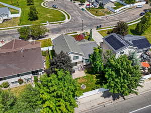 Aerial perspective showcasing a residential property with an expansive backyard featuring a manicured lawn and mature trees