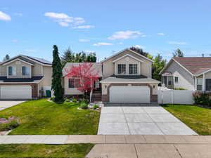Two-story residence featuring a two-car garage, brick and siding exterior, and a concrete driveway