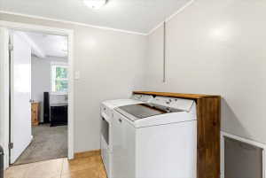 Dedicated laundry area featuring a wood-finish countertop, neutral wall paint, and ceramic tile flooring