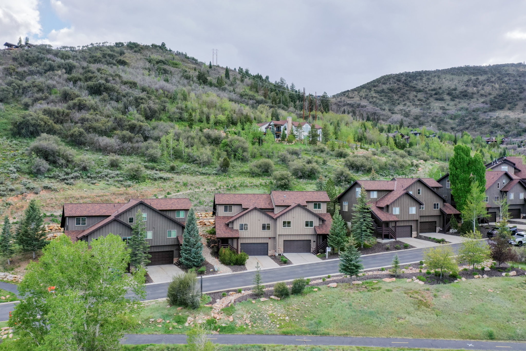 Contemporary multi-level residences featuring attached garages, pitched roofs, and mature landscaping