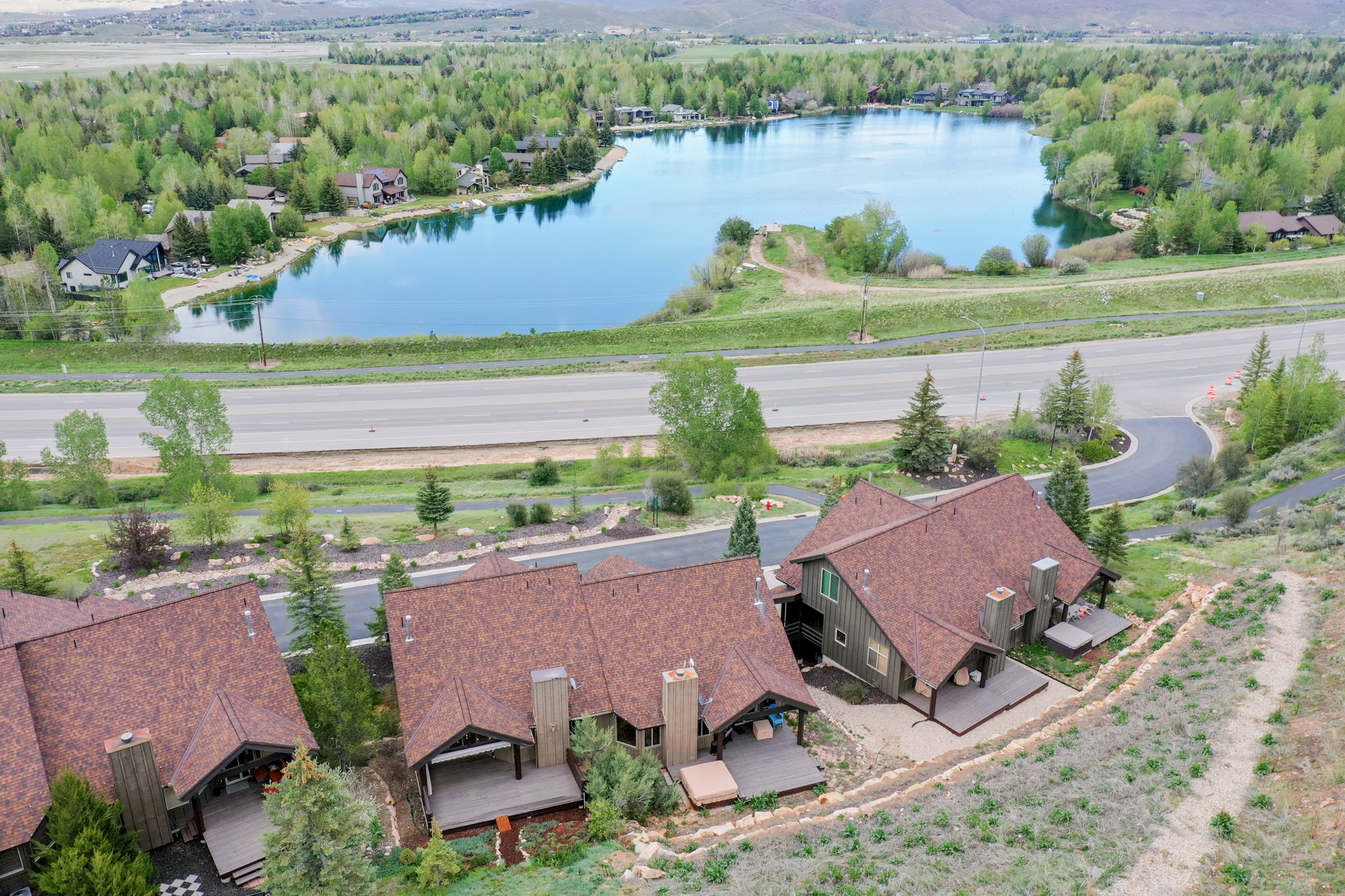 Residential properties with expansive rooflines, private decks, and a prominent water feature