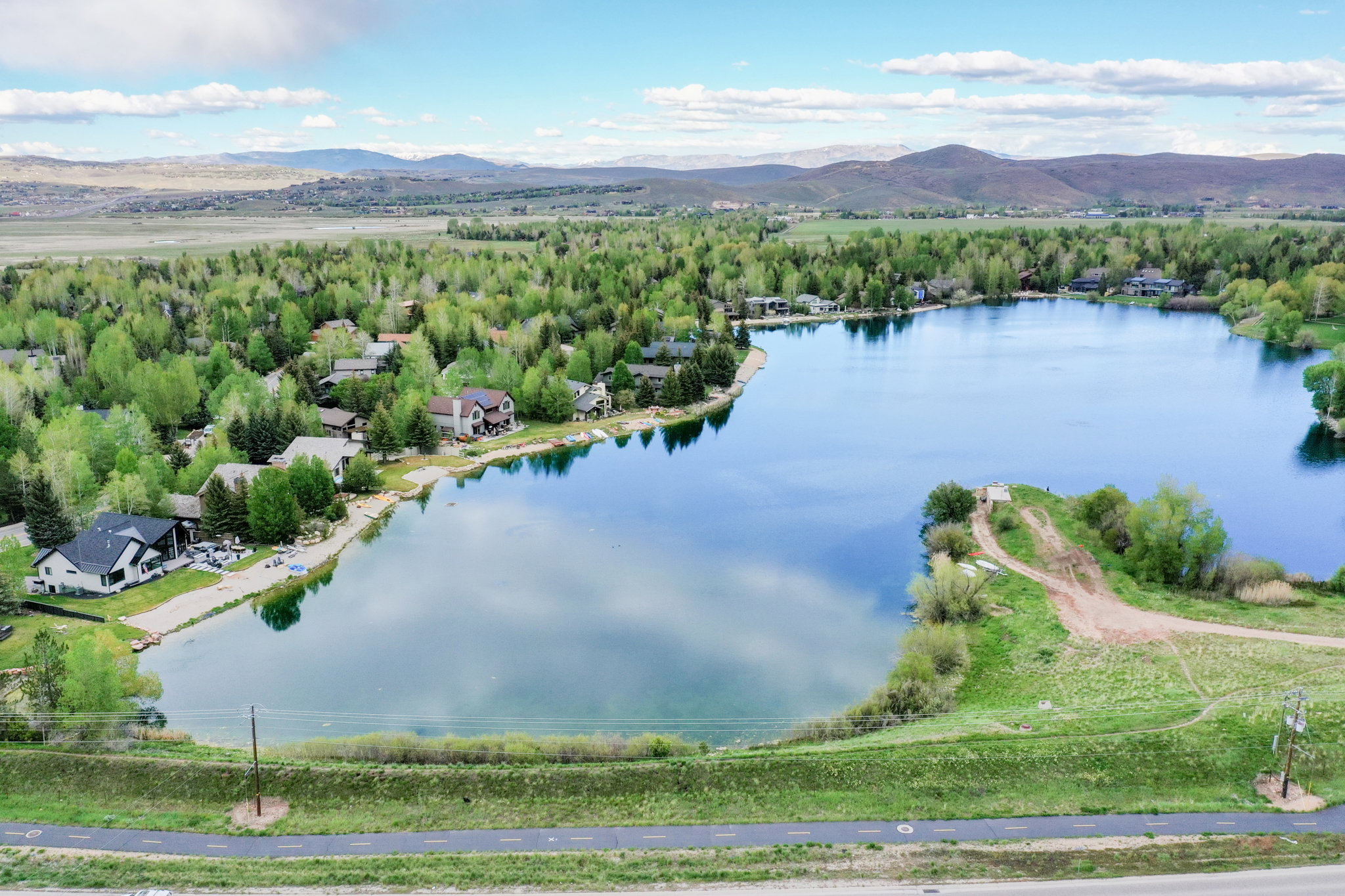 Expansive lakefront setting featuring a private lake, surrounding residential properties, and distant mountain ranges