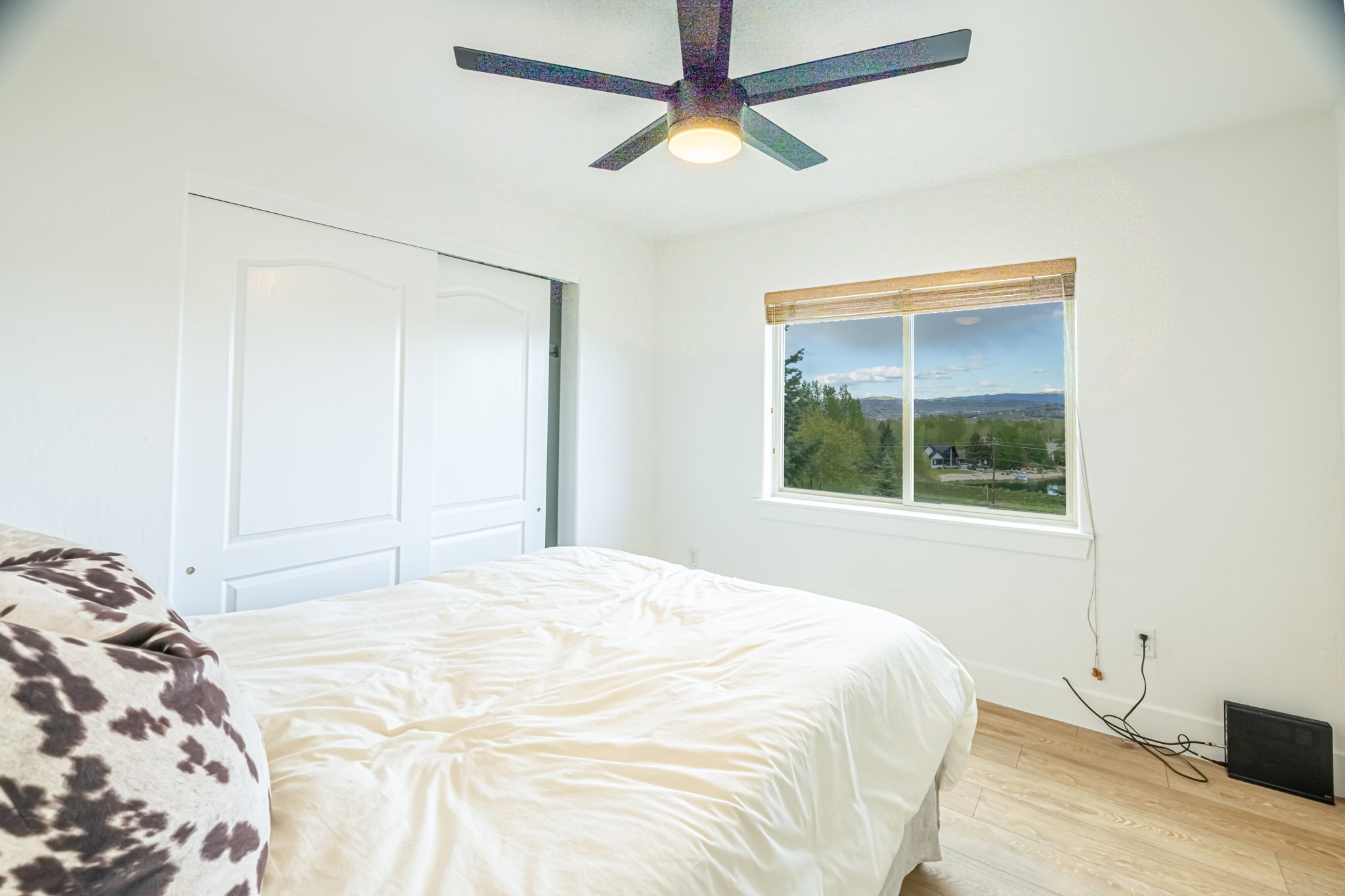 Light-filled interior featuring wood-finish flooring, a ceiling fan, and a window with natural light
