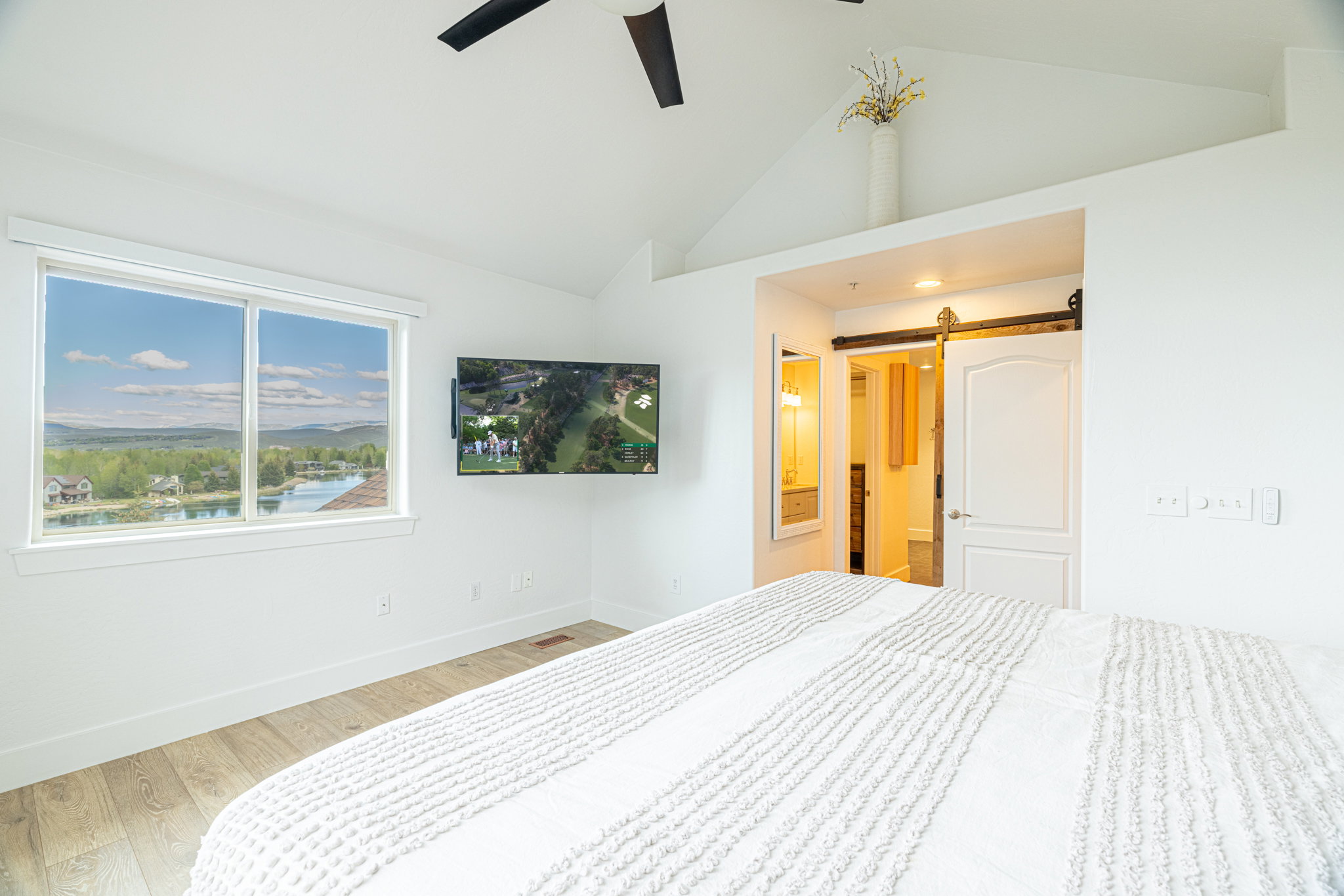 Bright interior with vaulted ceiling and wood-finish flooring