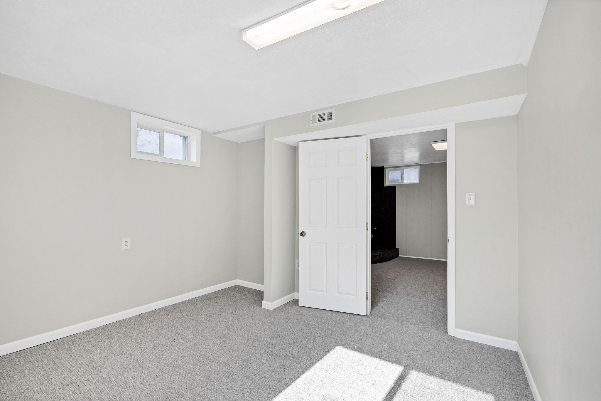Carpeted room with light grey walls and white trim