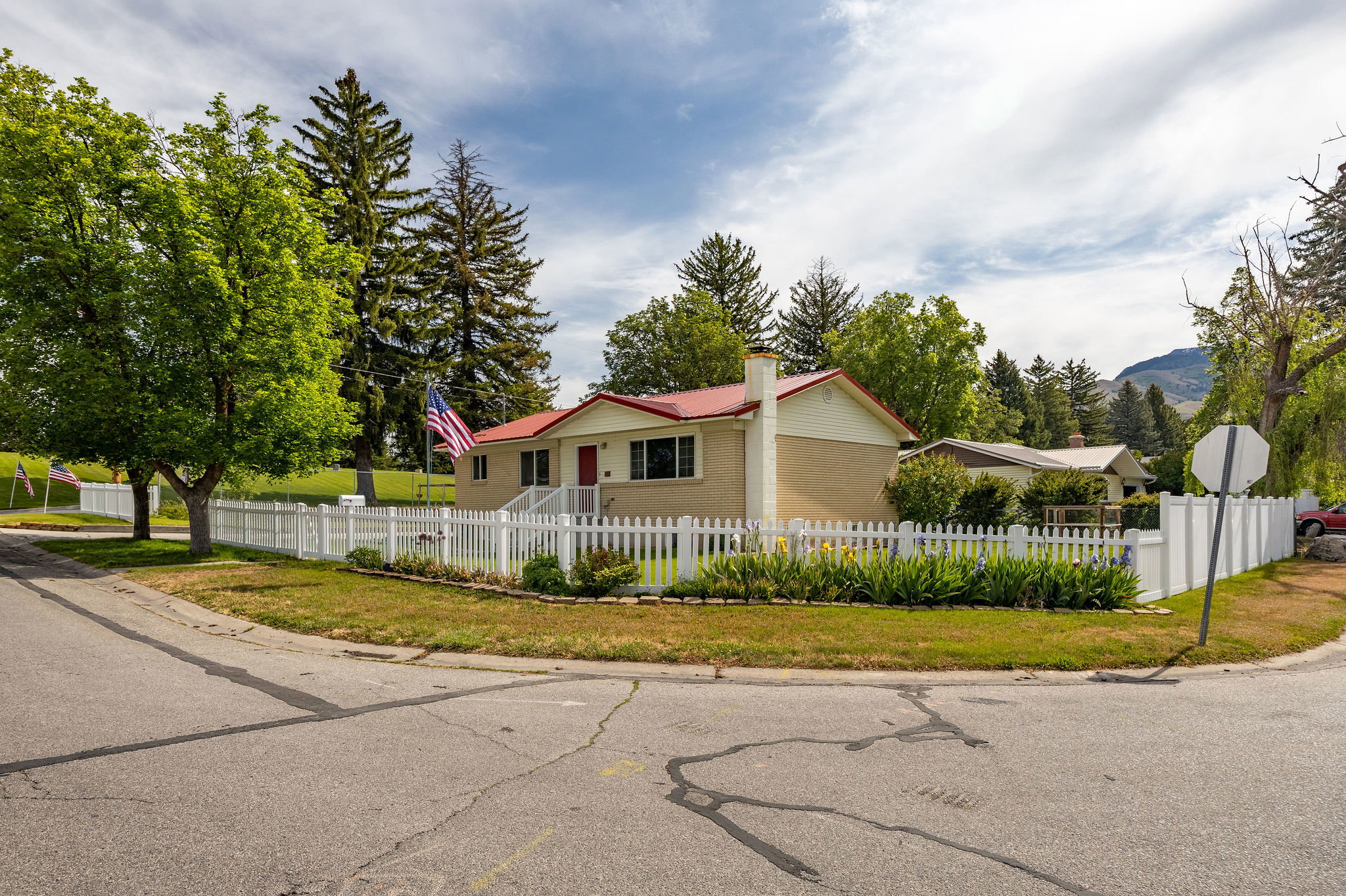 Single-story residence featuring a red roof and light-colored siding