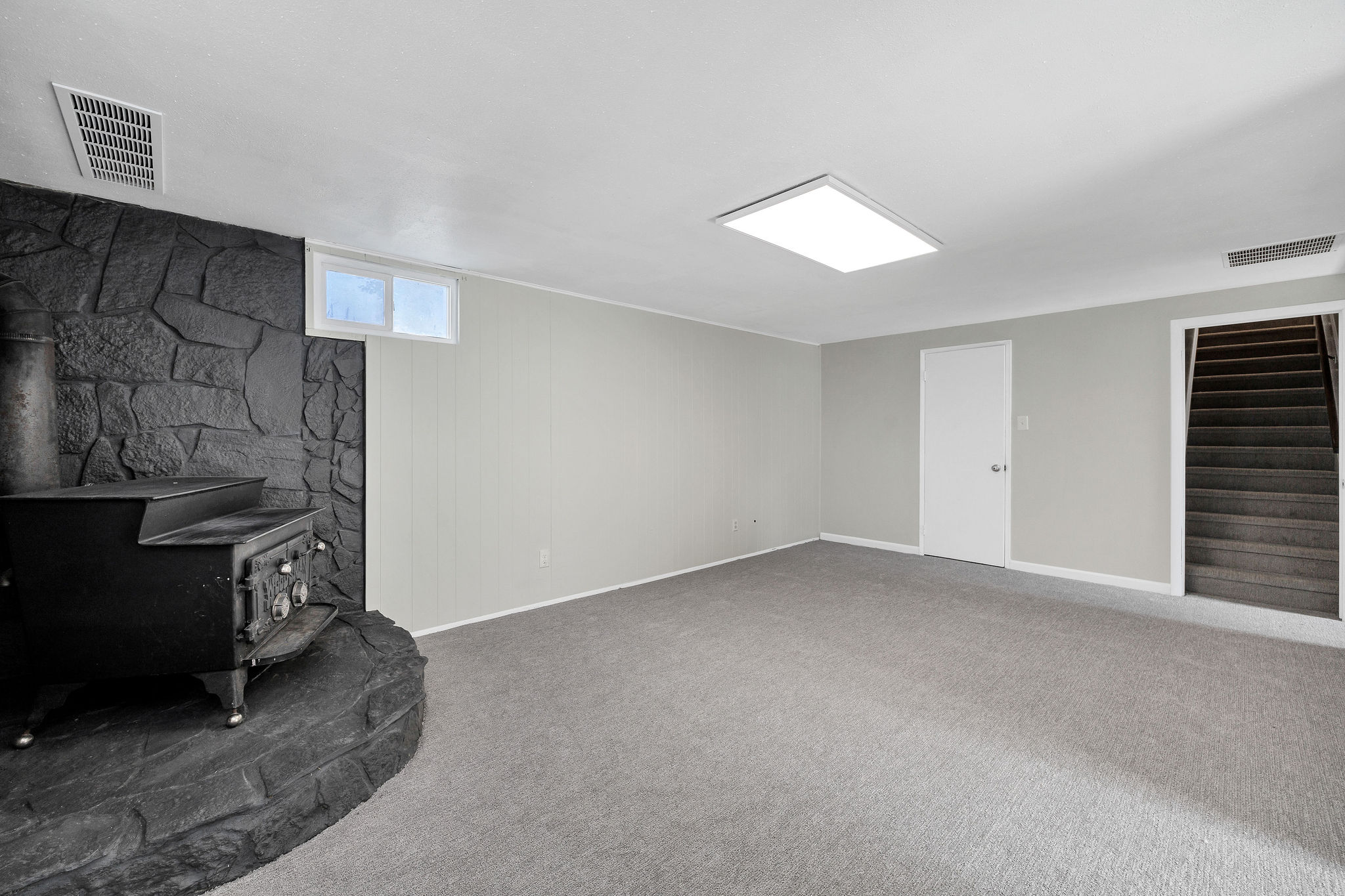 Spacious room with plush gray carpeting and light gray walls