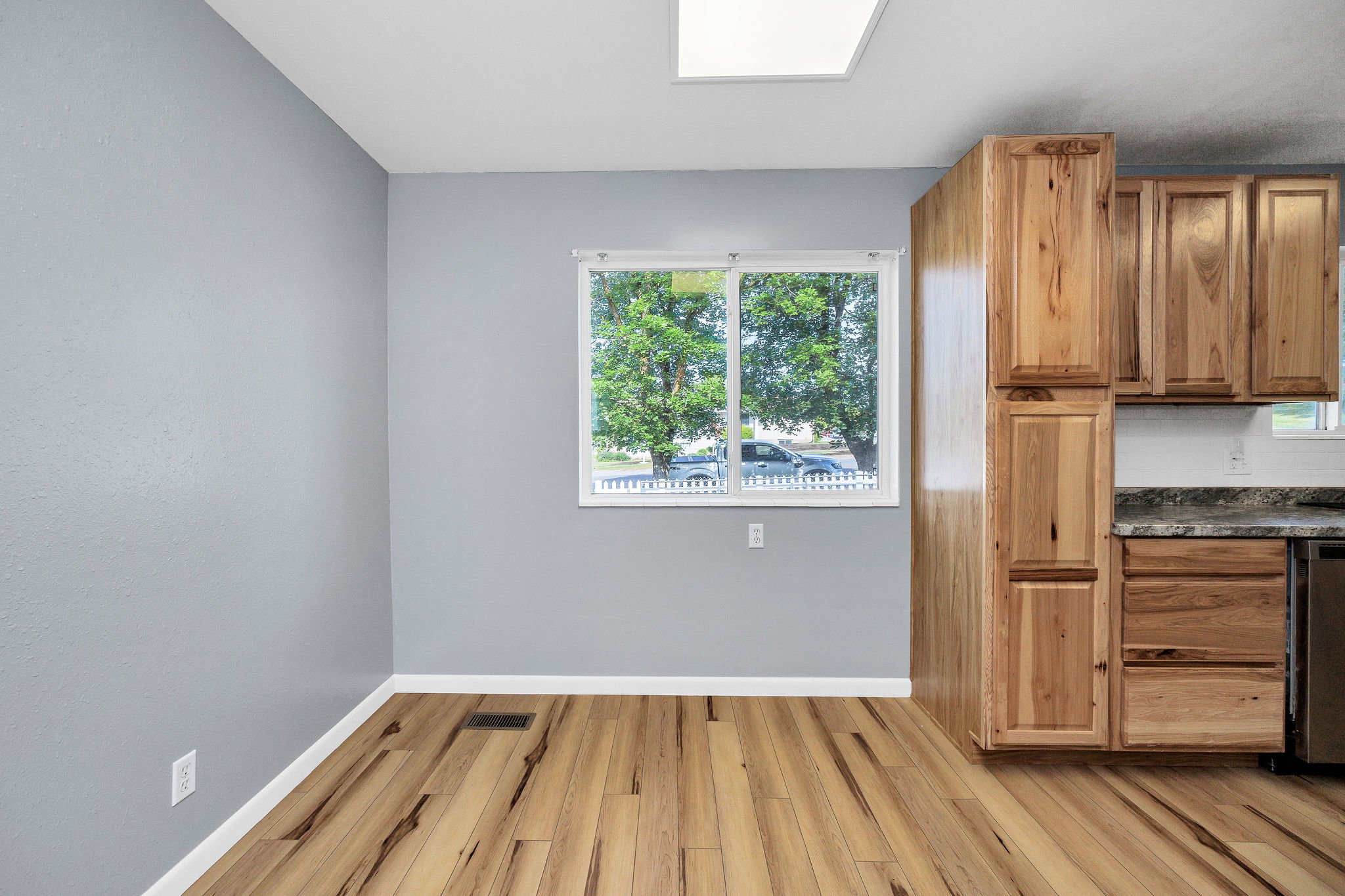 Kitchen or dining area featuring wood-finish flooring and light gray walls