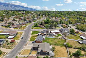 Residential neighborhood with mature trees, paved streets, and mountain backdrop