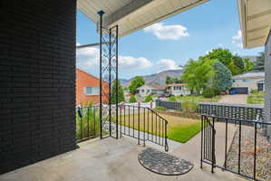 Front porch with black brick exterior and decorative wrought iron railings