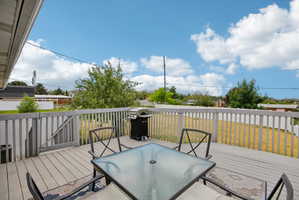 Spacious outdoor deck with wood-finish flooring and a white picket fence perimeter