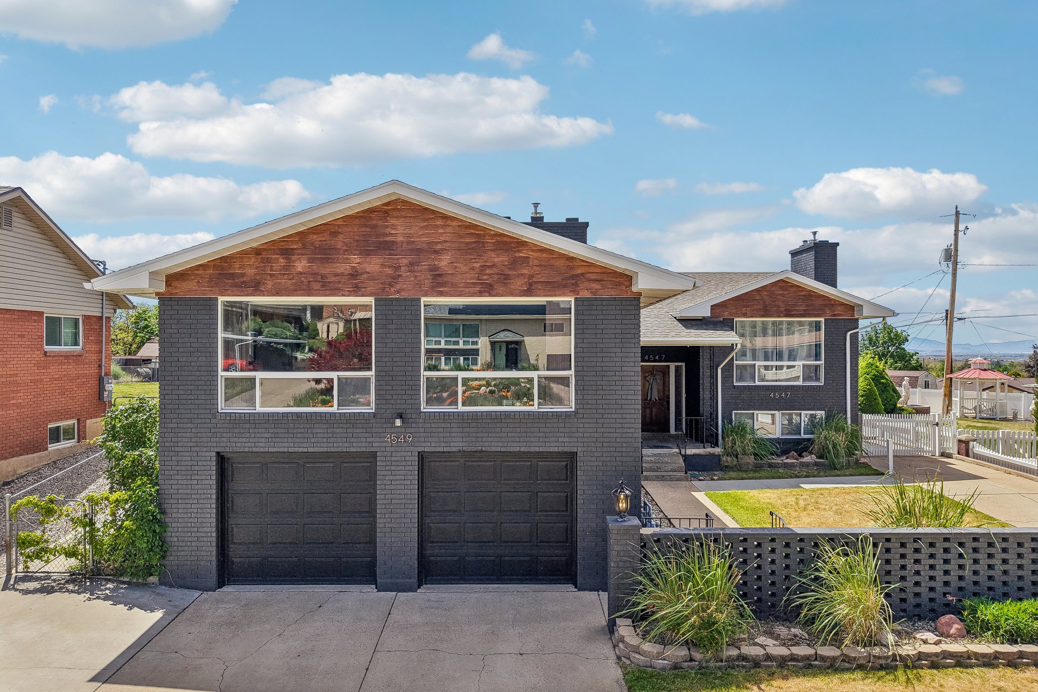 Contemporary-style exterior featuring gray brick and wood-finish siding accents
