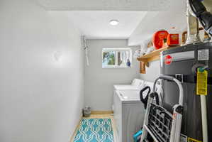 Dedicated laundry area featuring a window, overhead lighting, and wall shelving