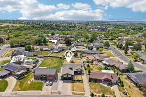 Residential neighborhood featuring a variety of architectural styles, mature trees, and mountainous terrain in the distance