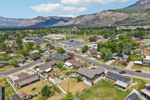Aerial perspective showcasing an established neighborhood with verdant trees and mountainous terrain