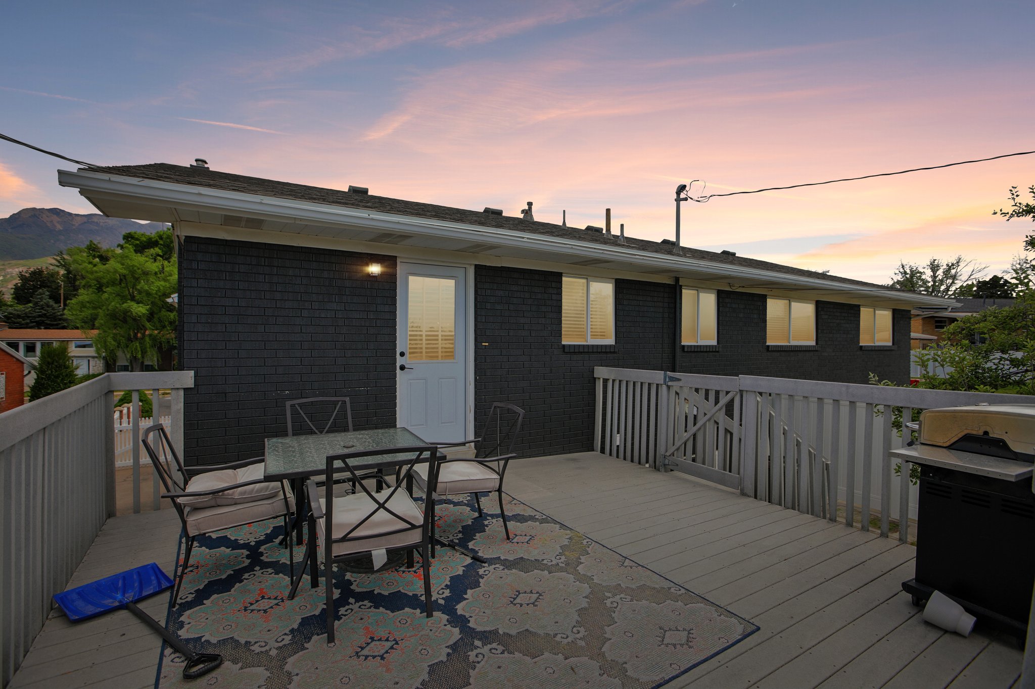 Expansive outdoor deck featuring composite decking, a white railing system, and direct access to the home via a white paneled door