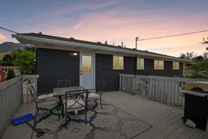 Expansive outdoor deck featuring composite decking, a white railing system, and direct access to the home via a white paneled door