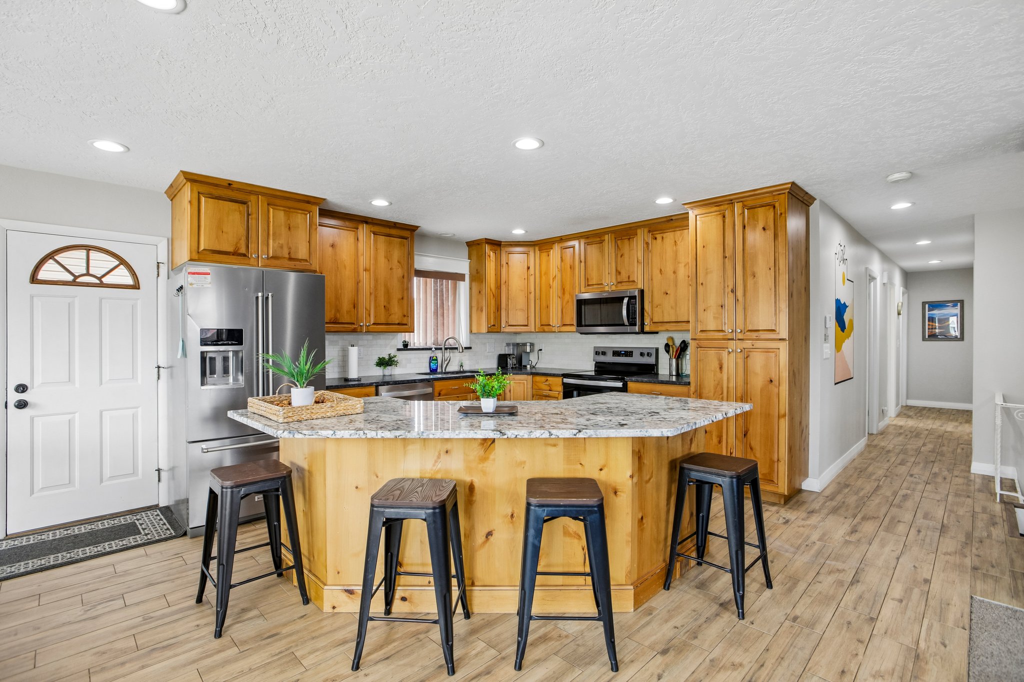 Kitchen featuring wood cabinetry, stainless steel appliances, and a central island with a light-toned countertop