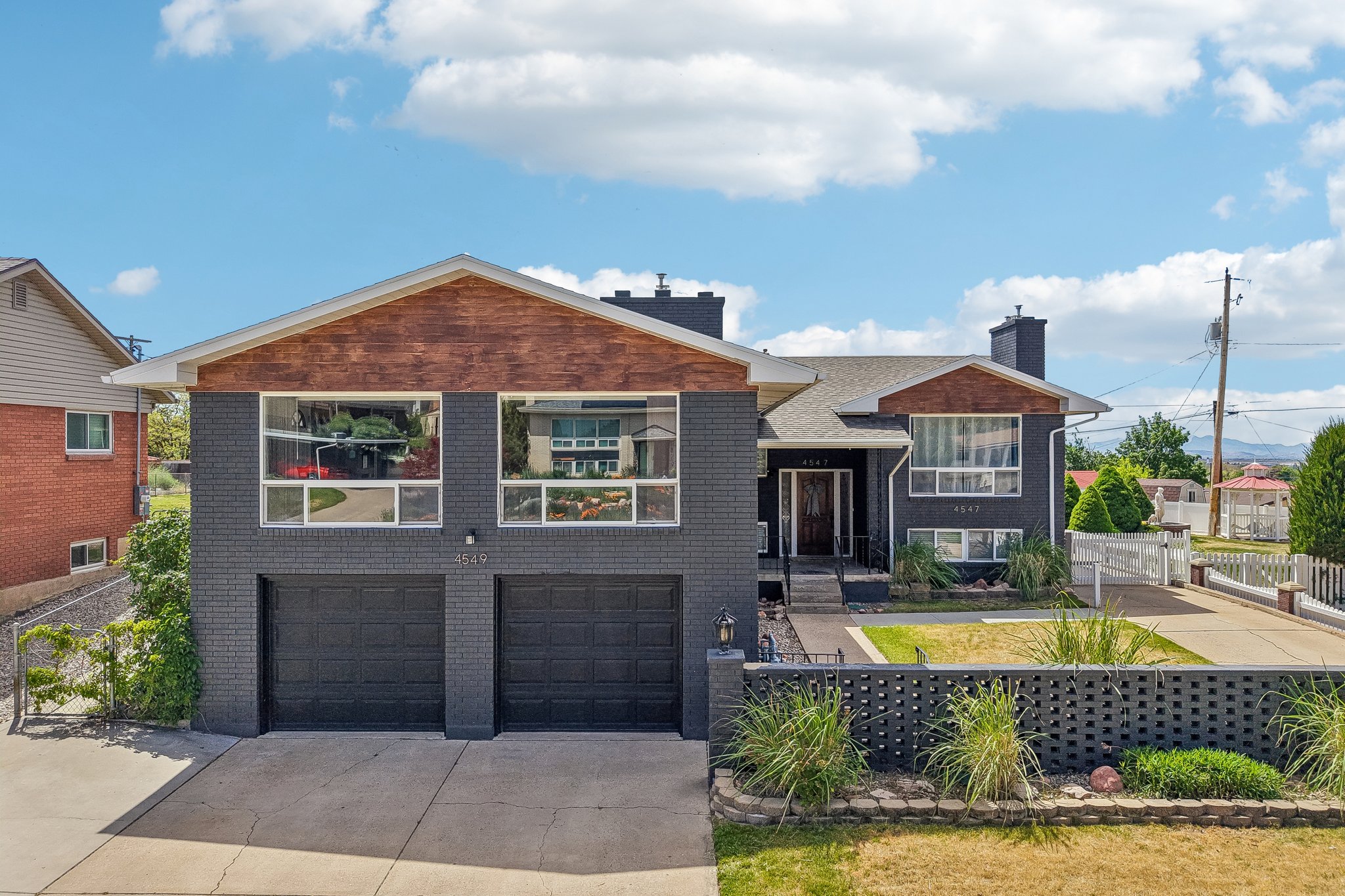 Modern exterior featuring dark gray brick and wood-finish siding accents