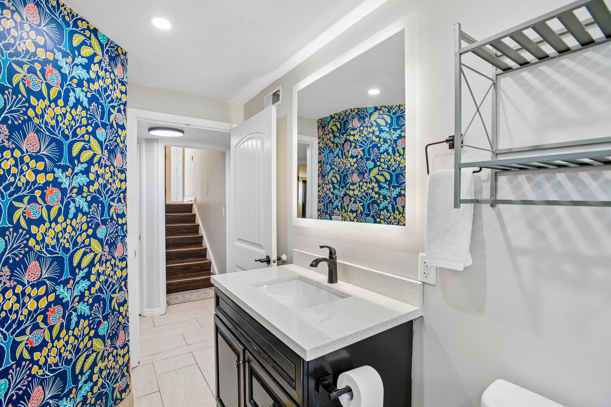 Bathroom featuring a contemporary vanity with an integrated sink, quartz countertop, and matte black faucet