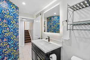 Bathroom featuring a contemporary vanity with an integrated sink, quartz countertop, and matte black faucet