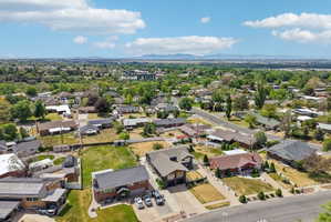 Aerial perspective showcasing a residential neighborhood with established trees and distant mountain ranges