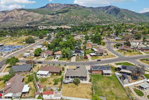 Residential neighborhood featuring a variety of single-family homes, mature trees, and mountainous terrain in the background