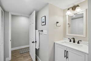 Bathroom featuring a white vanity with a rectangular sink, matte black faucet, and white countertop