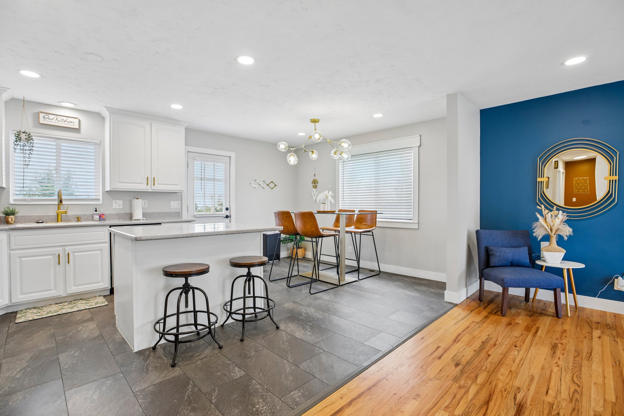 Open-concept kitchen and dining area featuring white cabinetry, light-colored countertops, and a kitchen island with seating