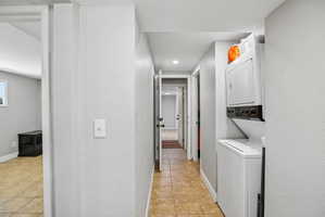 Hallway featuring tile flooring, recessed lighting, and a stacked washer and dryer unit