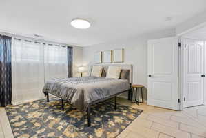 Bedroom featuring light tile flooring and a decorative area rug