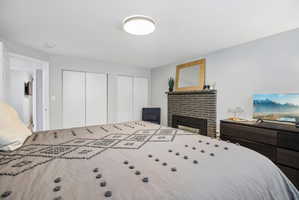 Bedroom featuring a modern fireplace with a dark brick surround