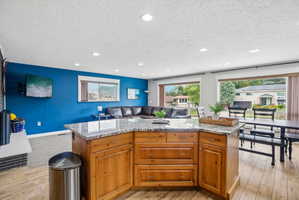 Kitchen island with wood-finish cabinetry and a speckled countertop