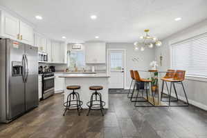 Open-concept kitchen and dining area featuring wood-finish plank flooring