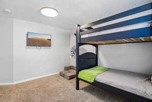 Carpeted room with a wall-mounted television and a flush-mount ceiling light