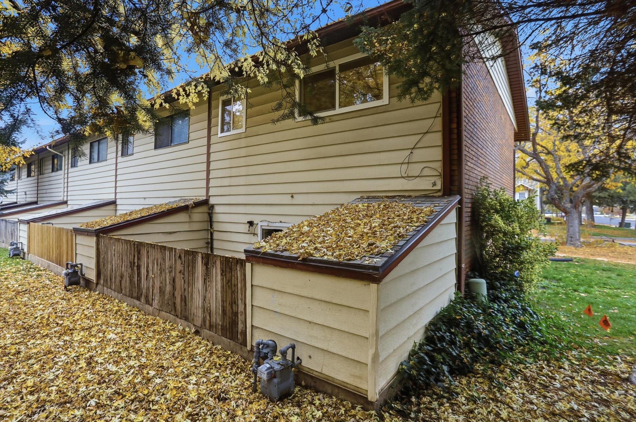 Exterior siding in a neutral tone with a brick accent wall