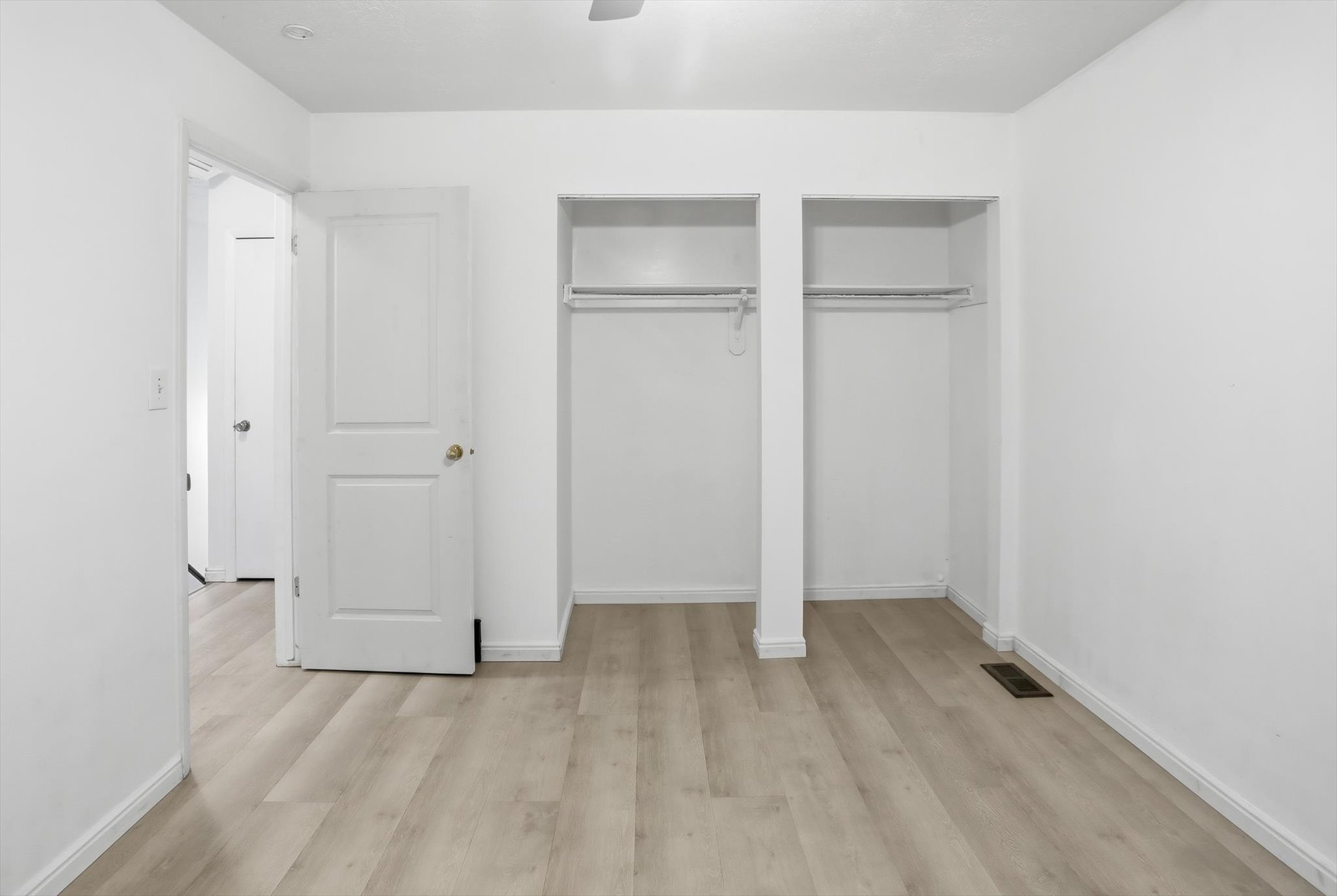 Room featuring light wood-finish flooring, white walls, and white baseboards